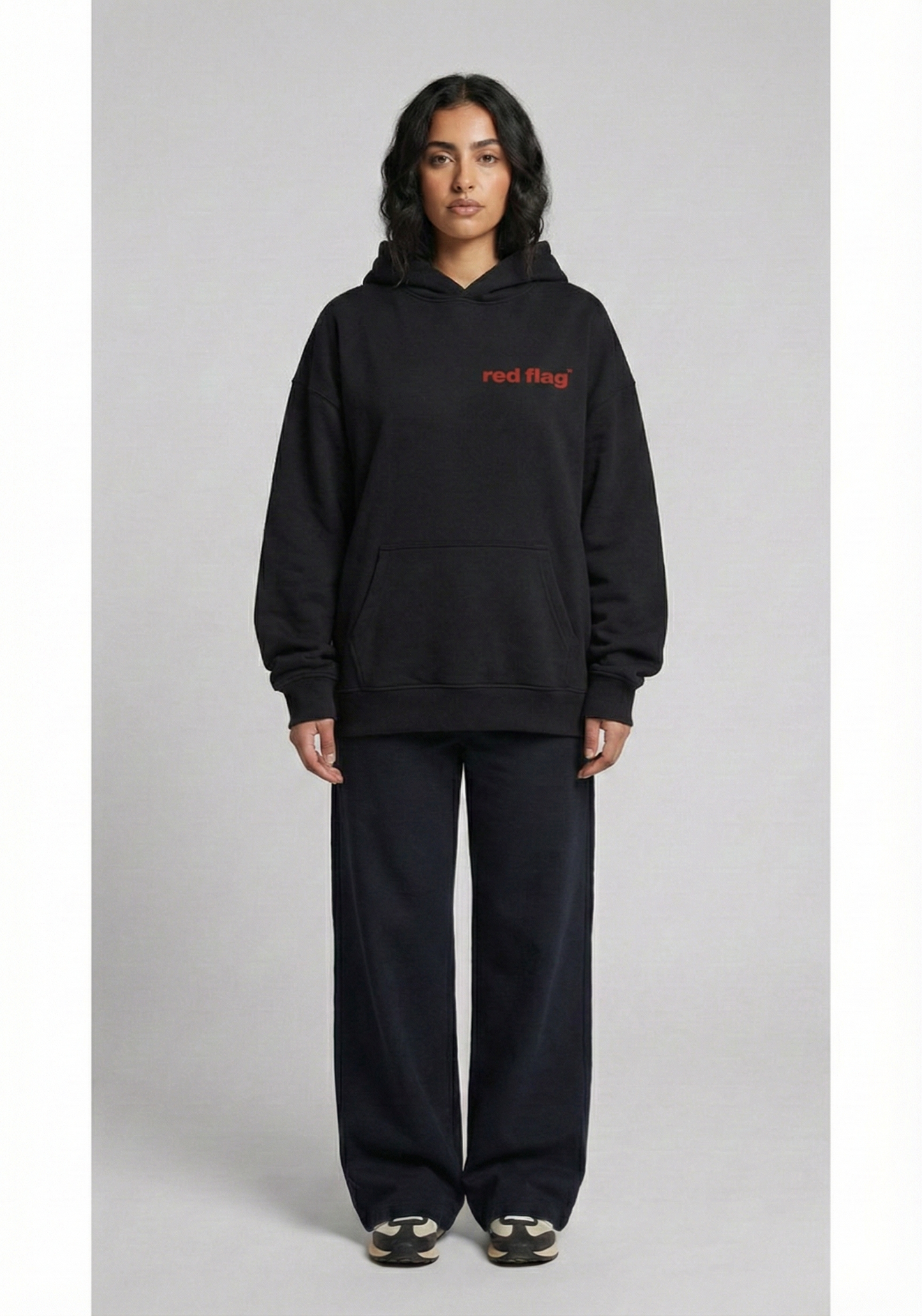 Person wearing a black hoodie with red text on a gray background