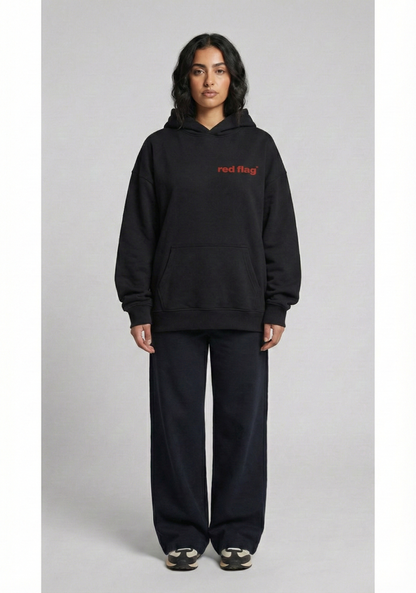 Person wearing a black hoodie with red text on a gray background